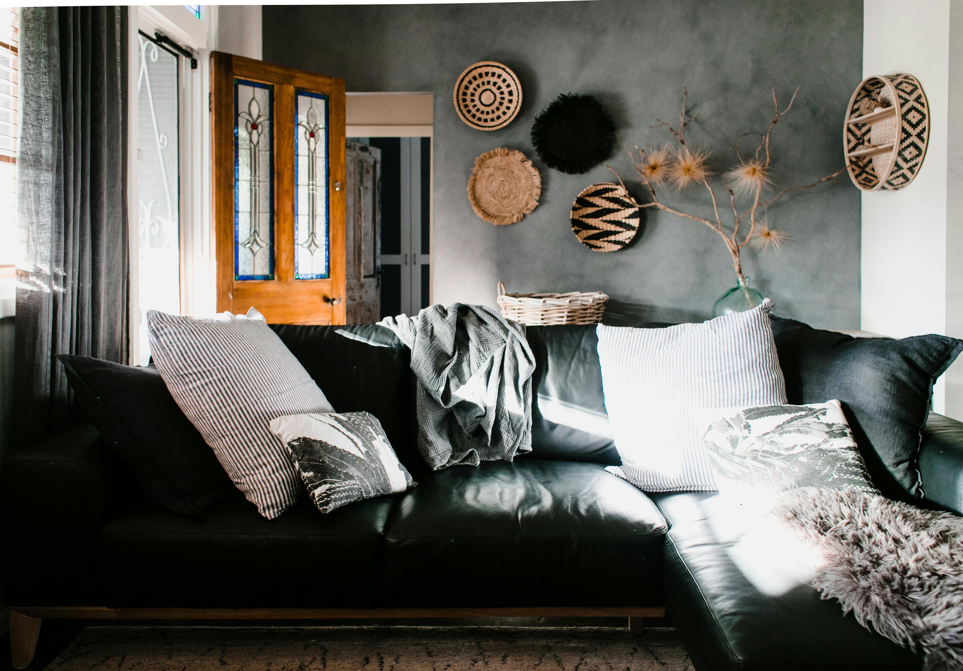 Living room with a dark sofa, decorative pillows, and wall art.
