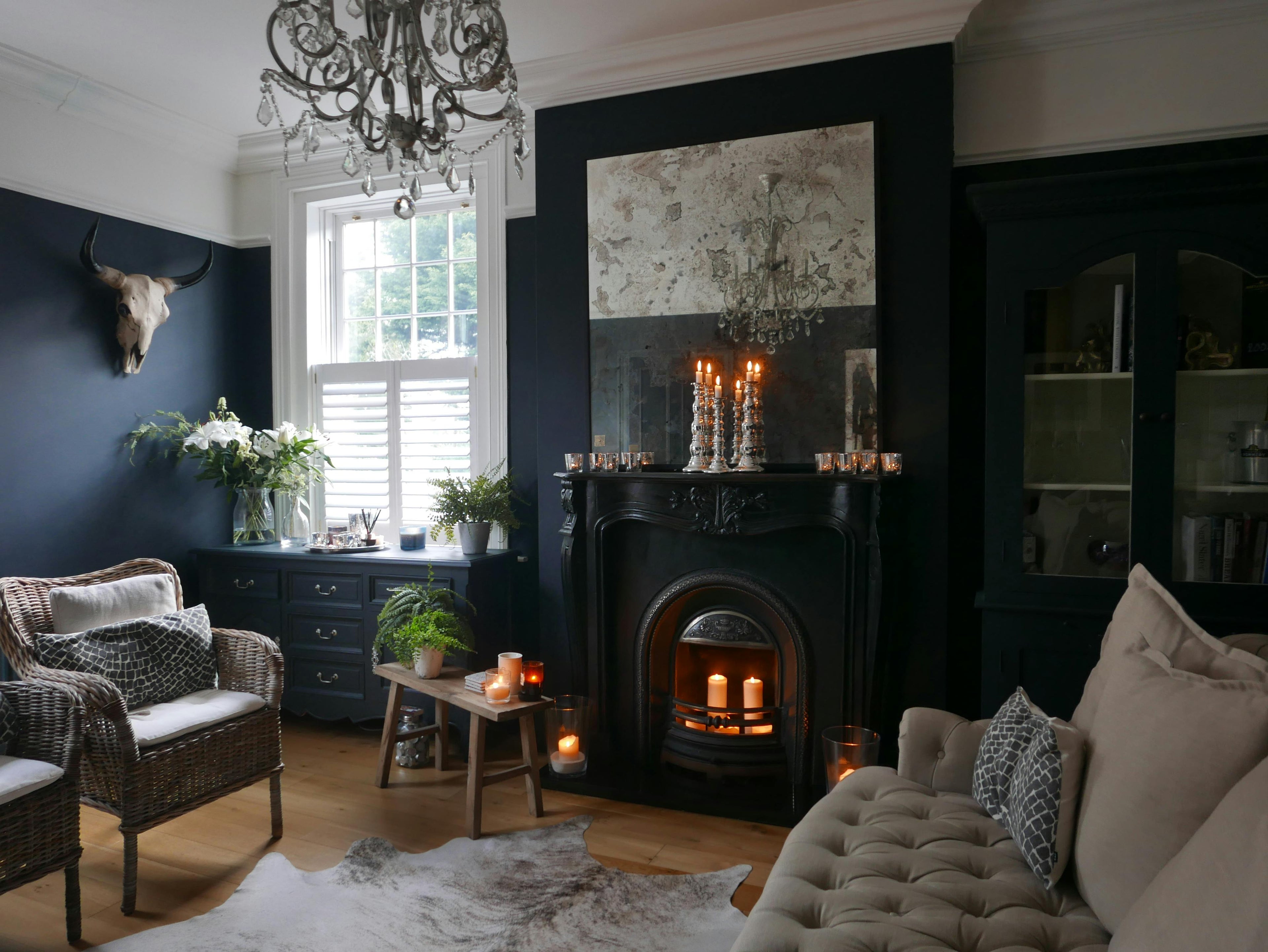 Cozy living room with dark walls, fireplace, and decorative elements.